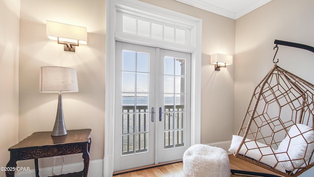 doorway featuring french doors, a water view, ornamental molding, and light hardwood / wood-style floors