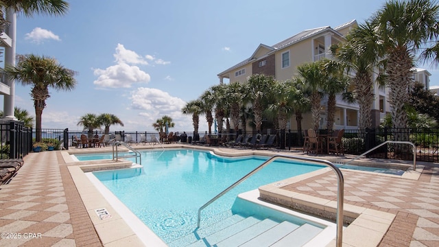 view of swimming pool with a hot tub and a patio