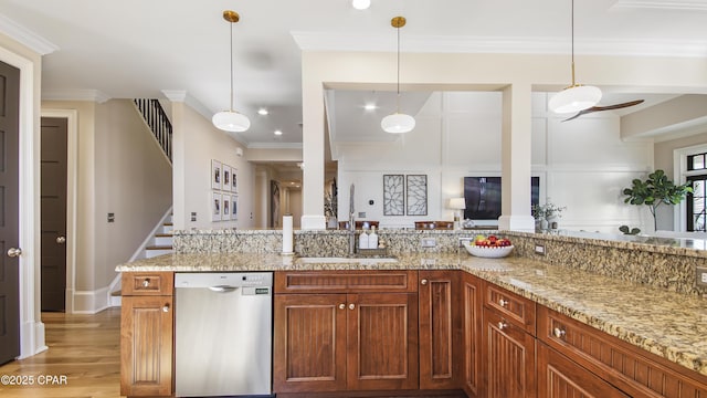 kitchen featuring sink, ornamental molding, dishwasher, pendant lighting, and light stone countertops