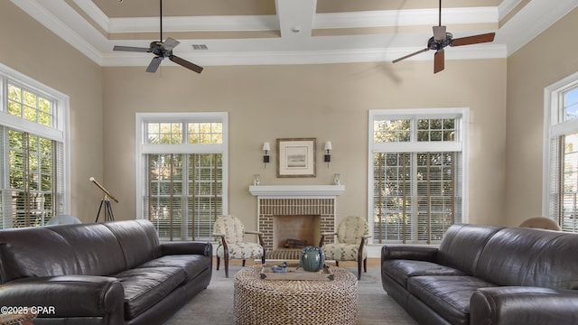 living room with a fireplace, plenty of natural light, ornamental molding, and ceiling fan