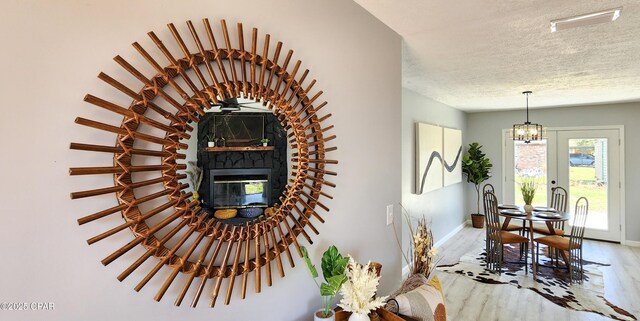 unfurnished bedroom with ceiling fan, a textured ceiling, light hardwood / wood-style floors, and a closet