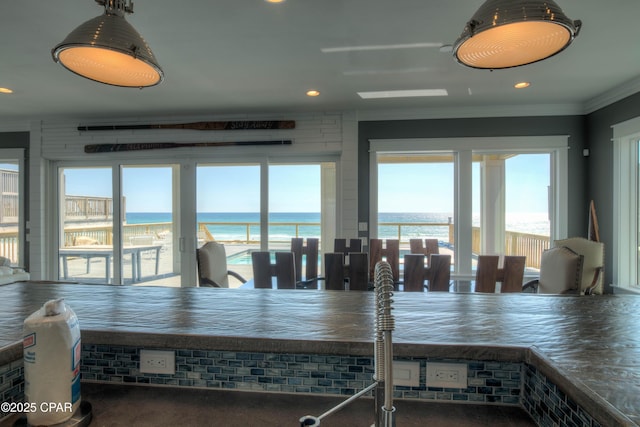 dining space featuring ornamental molding and a water view