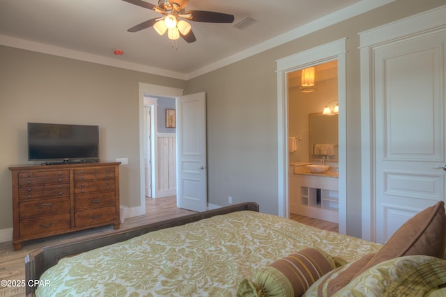 bedroom with connected bathroom, hardwood / wood-style floors, and crown molding