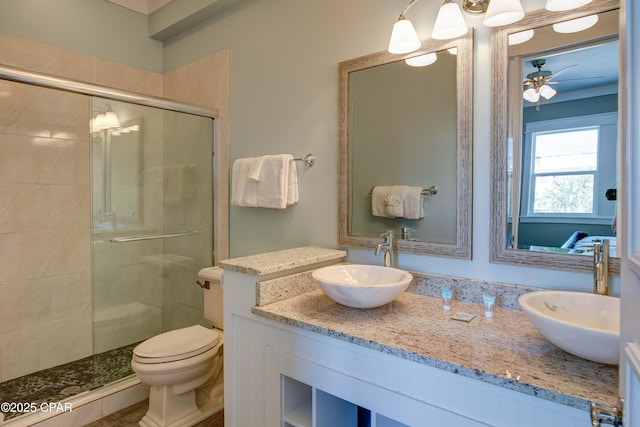 bathroom featuring ceiling fan, vanity, toilet, and an enclosed shower