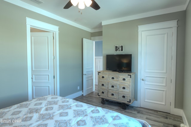 bedroom with crown molding, light hardwood / wood-style floors, and ceiling fan