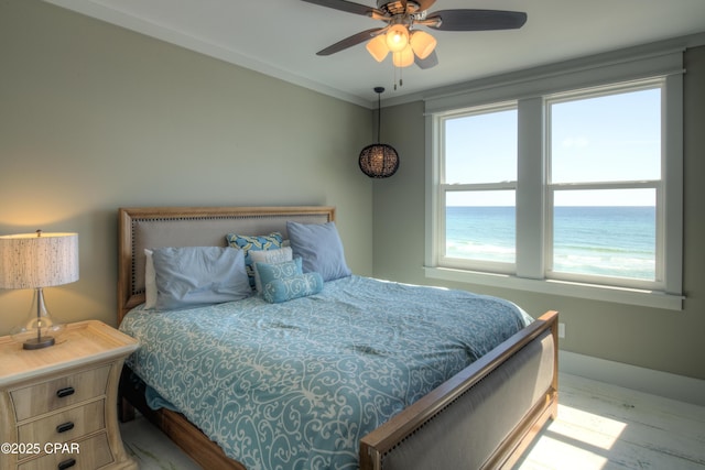 bedroom featuring light wood-type flooring, ceiling fan, and a water view