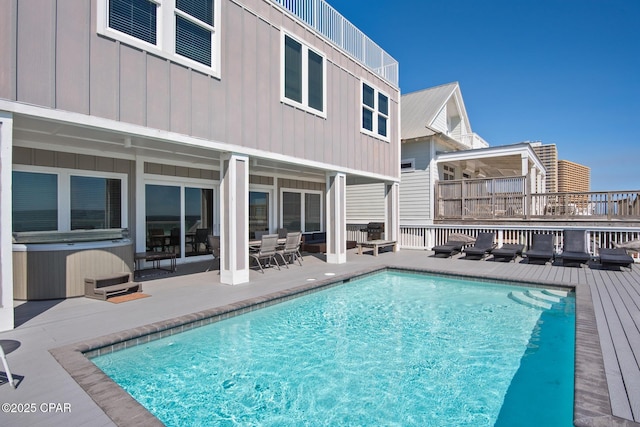 view of swimming pool with a wooden deck and a hot tub