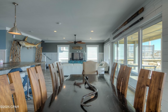 dining space with ornamental molding, hardwood / wood-style floors, and ceiling fan