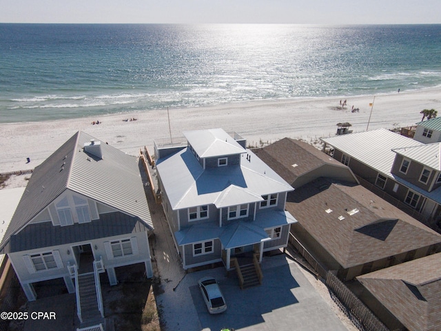 birds eye view of property with a water view and a beach view