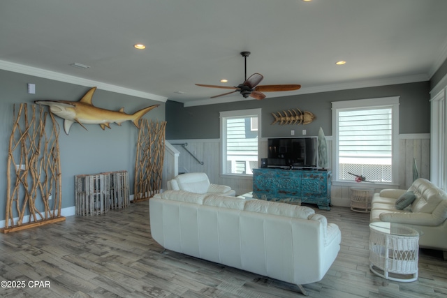 living room featuring ceiling fan, ornamental molding, and light hardwood / wood-style floors