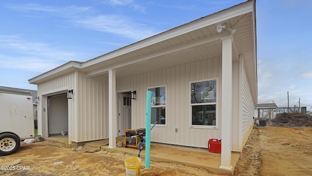 view of exterior entry featuring cooling unit and a garage