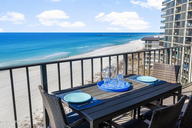 balcony featuring a view of the beach and a water view