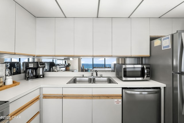 kitchen with sink, stainless steel appliances, and white cabinets