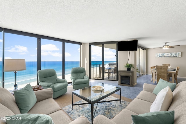 living room with ceiling fan, floor to ceiling windows, and a textured ceiling