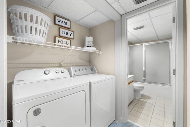 laundry area with light tile patterned floors and washer and clothes dryer