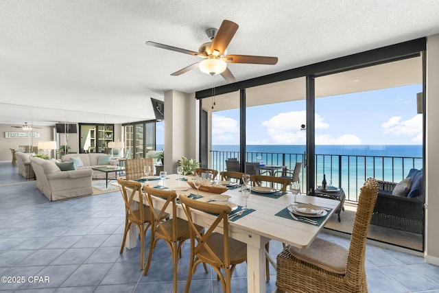 dining room featuring ceiling fan, floor to ceiling windows, a textured ceiling, and light tile patterned floors