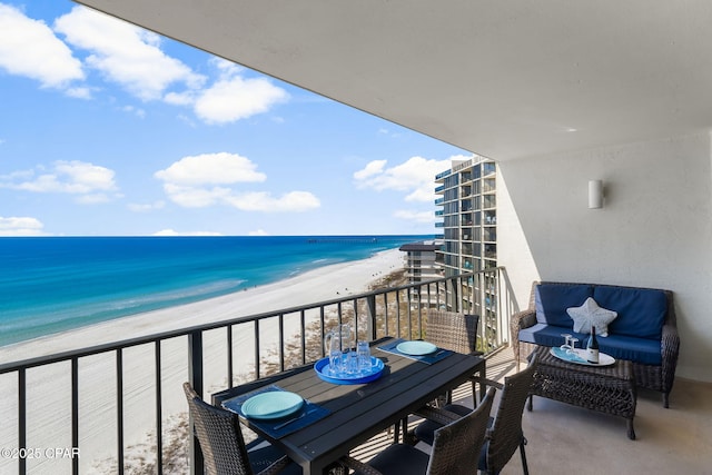 balcony featuring a water view and a beach view