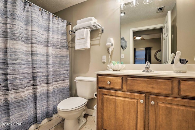 bathroom featuring tile patterned flooring, vanity, a textured ceiling, and toilet