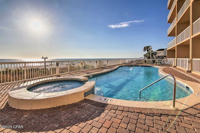 view of swimming pool with a hot tub