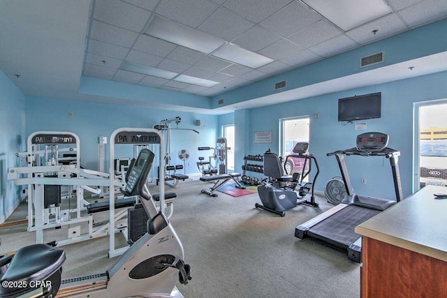 exercise room with a raised ceiling and a drop ceiling