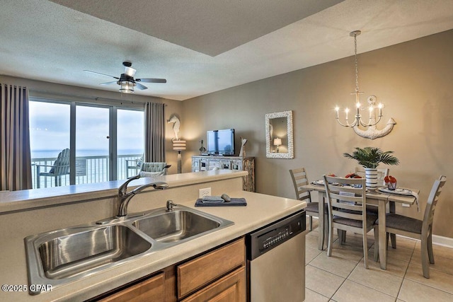kitchen with sink, a textured ceiling, light tile patterned floors, dishwasher, and pendant lighting
