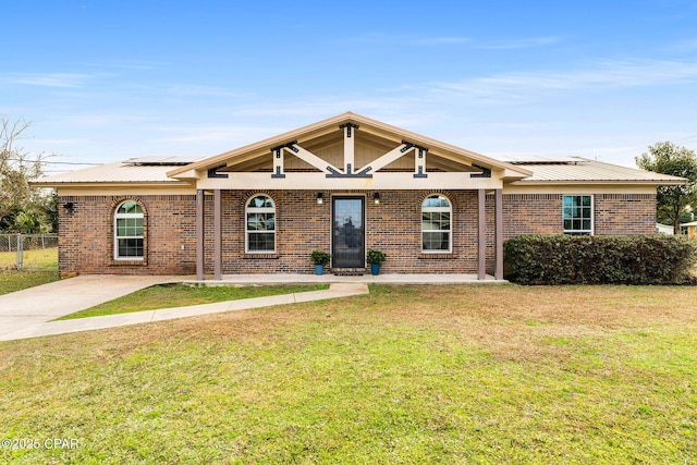 single story home with a front yard and solar panels