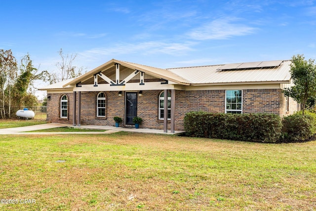 view of front of home with a front lawn and solar panels