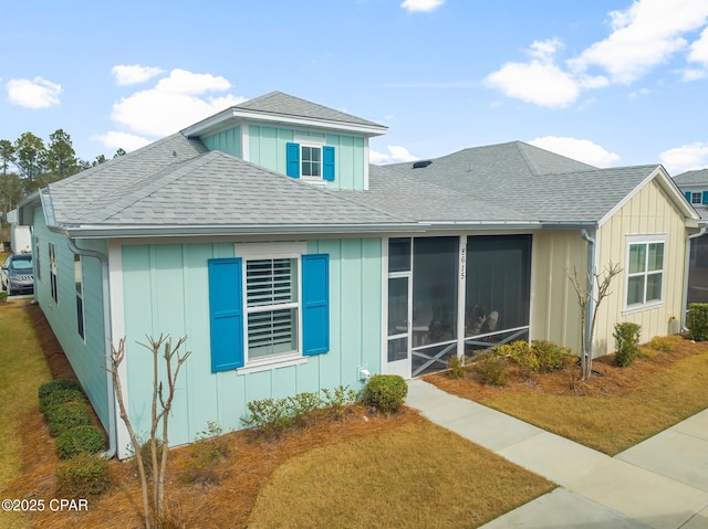 view of front of property with a sunroom and a front yard