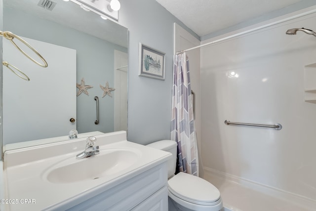 bathroom with vanity, curtained shower, a textured ceiling, and toilet