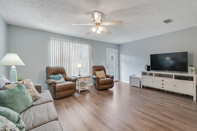 living room with wood-type flooring, a textured ceiling, and ceiling fan