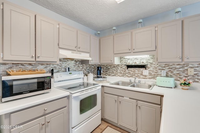 kitchen with sink, decorative backsplash, white cabinets, and white electric range oven