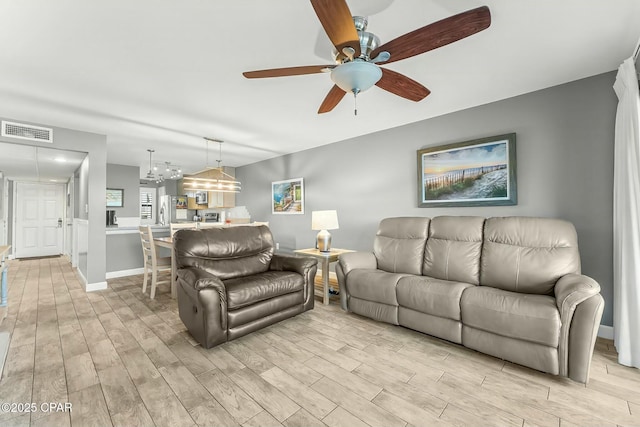 living room with light hardwood / wood-style flooring and ceiling fan