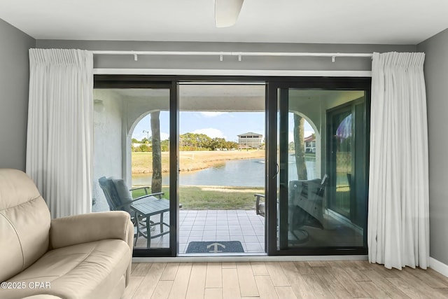 doorway featuring a water view and light wood-type flooring