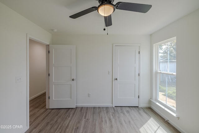 unfurnished bedroom featuring light wood-type flooring, ceiling fan, and baseboards