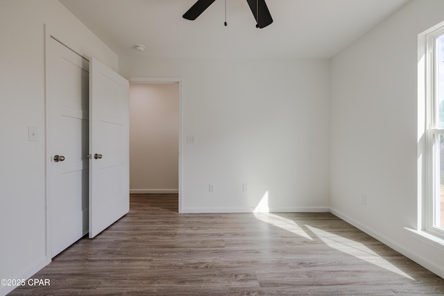 unfurnished bedroom featuring light wood-style flooring, baseboards, and ceiling fan