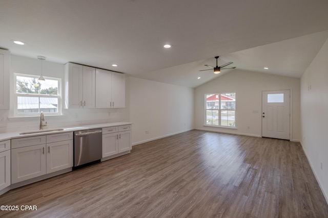 kitchen with a sink, white cabinets, light countertops, and stainless steel dishwasher