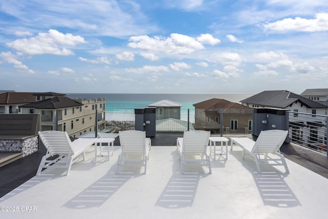 view of patio with a water view and a beach view