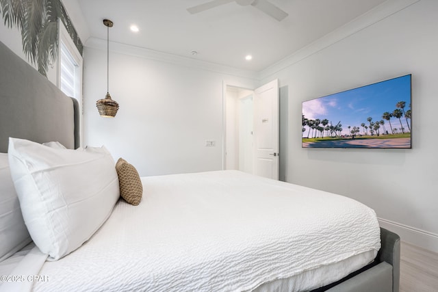 bedroom featuring hardwood / wood-style flooring, ceiling fan, and ornamental molding