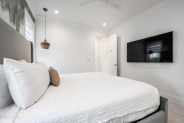 bedroom with ornamental molding, wood-type flooring, and ceiling fan