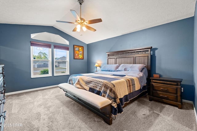 bedroom featuring carpet floors, vaulted ceiling, baseboards, and a ceiling fan