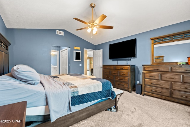 bedroom featuring lofted ceiling, ensuite bathroom, carpet flooring, visible vents, and a ceiling fan