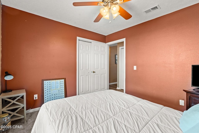 carpeted bedroom with baseboards, a closet, visible vents, and a ceiling fan