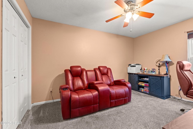 carpeted home theater room featuring a textured ceiling, baseboards, and a ceiling fan