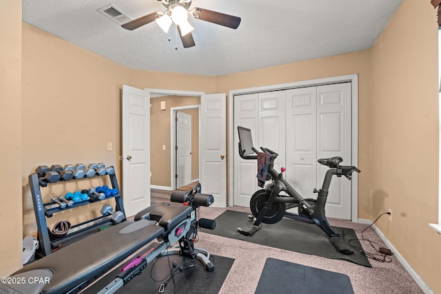 workout area featuring a ceiling fan, visible vents, and baseboards