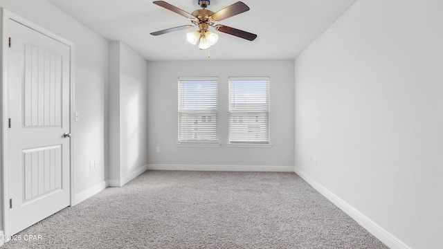 unfurnished room with carpet floors, a ceiling fan, and baseboards