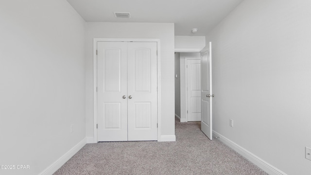 unfurnished bedroom featuring carpet, a closet, visible vents, and baseboards