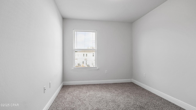 unfurnished room with carpet and baseboards