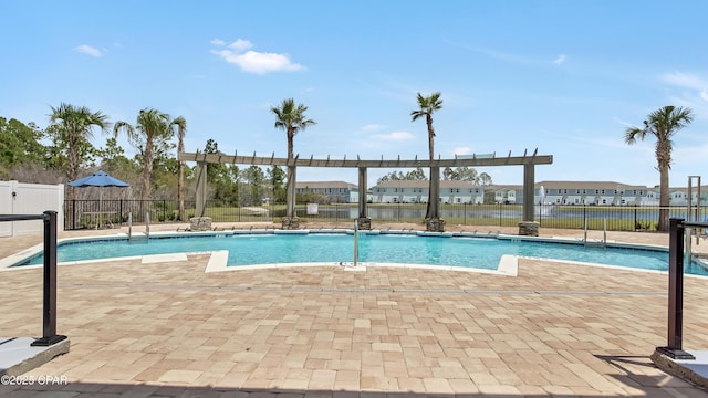 community pool with a patio area and fence