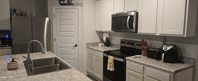 kitchen featuring white cabinetry, sink, and appliances with stainless steel finishes