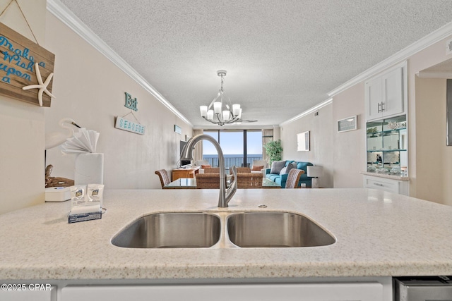 kitchen with crown molding, a notable chandelier, and a sink